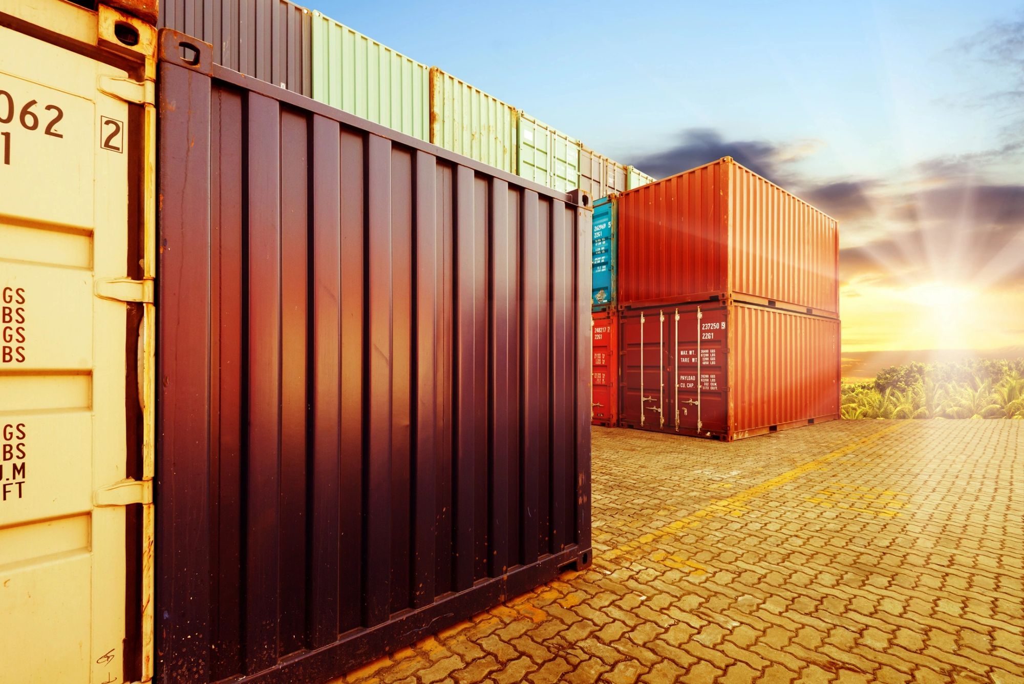 Stacked shipping containers at sunset.